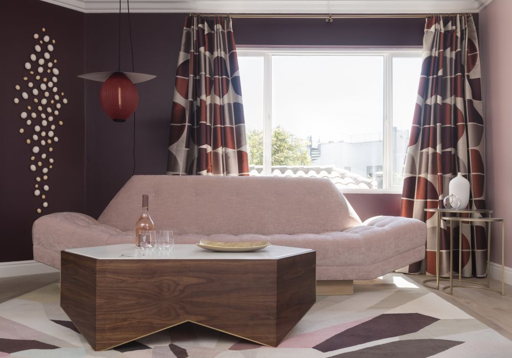 Coddington-bay-area-pink-sofa-lighting-fixture-area-rug-coffee-table-colorful-creative-console