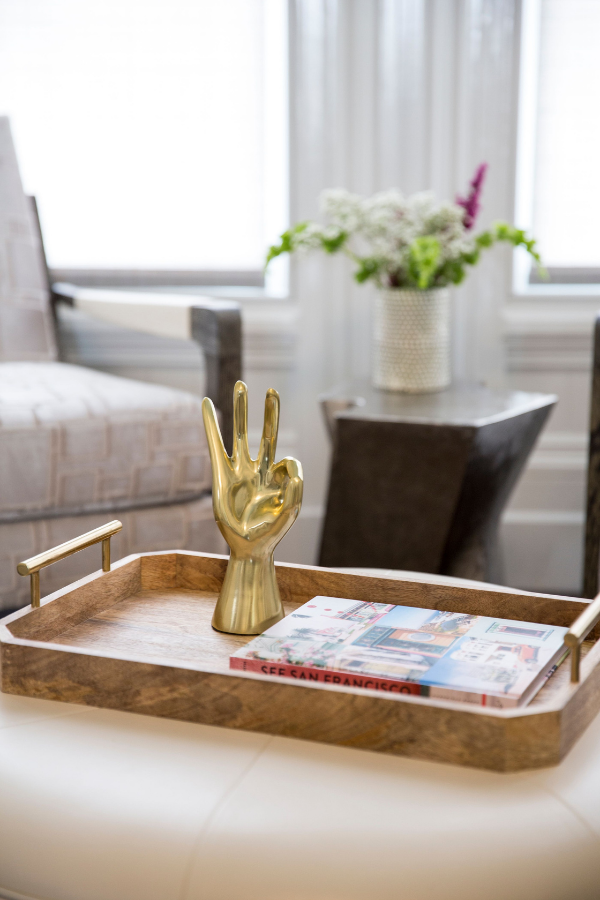 coddington-design-sherman-oaks-ca-cost-to-furnish-a-home-coffee-table-decor-coffe-table-book-wood-tray-gold-detailing-gold-hand-sculpture-showing-three